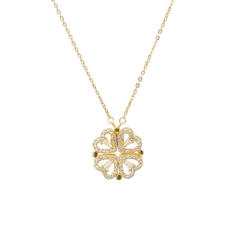 gold layered necklace — one chain with a four-leaf clover pendant and the other with small heart-shaped pendants.