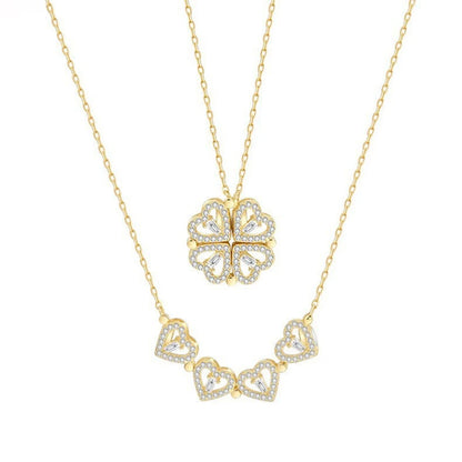 gold layered necklace — one chain with a four-leaf clover pendant and the other with small heart-shaped pendants.